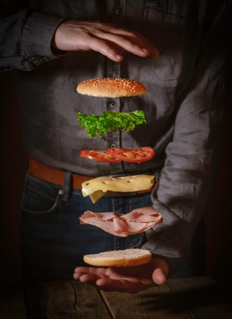 person in black button up shirt with burger